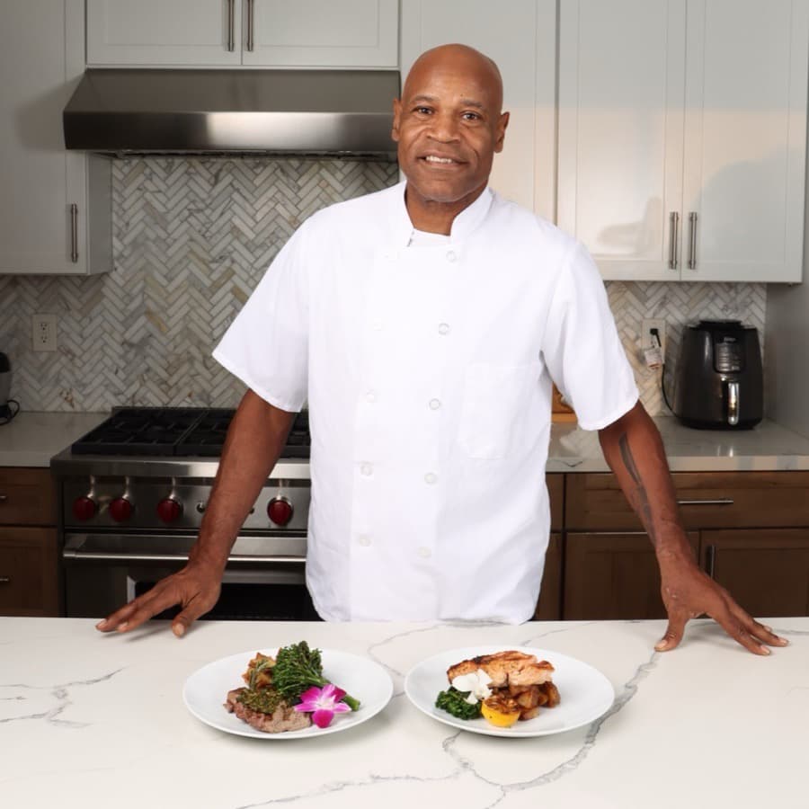 Snook in his chef's whites with two plated meals